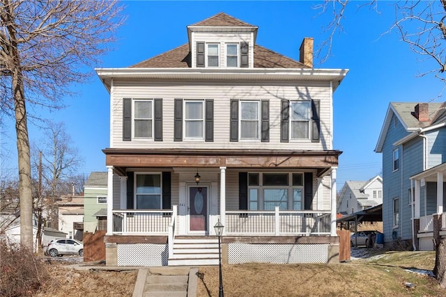 american foursquare style home with covered porch and a chimney