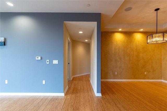 interior space with recessed lighting, a notable chandelier, baseboards, and wood finished floors