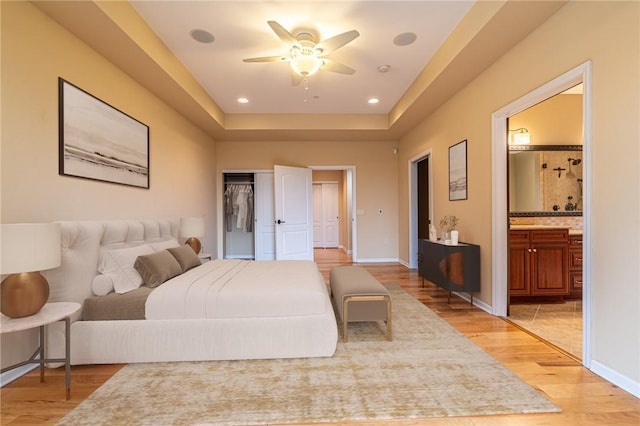 bedroom featuring recessed lighting, baseboards, ensuite bath, and light wood finished floors