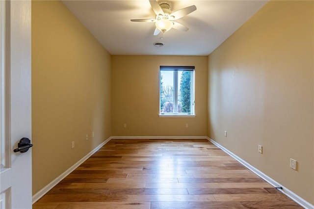 empty room with light wood-type flooring, baseboards, visible vents, and a ceiling fan