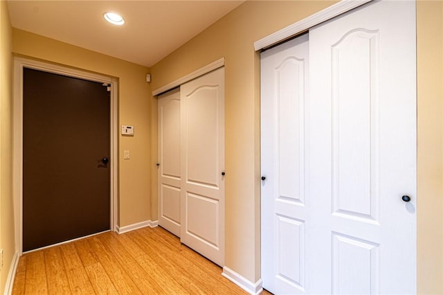 hallway featuring light wood-style flooring and baseboards