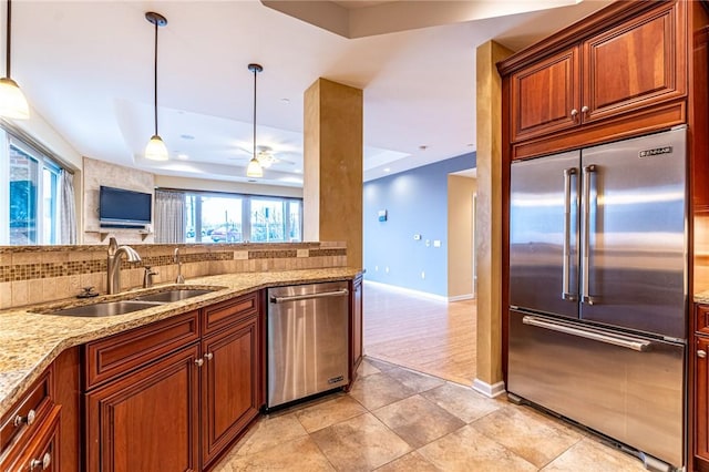 kitchen featuring stainless steel appliances, a tray ceiling, a sink, and backsplash