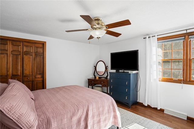 bedroom with a ceiling fan, visible vents, and dark wood-type flooring