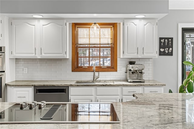 kitchen featuring a wealth of natural light, white cabinets, and a sink