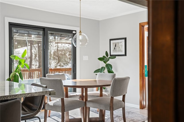 dining space featuring light tile patterned flooring, crown molding, and baseboards