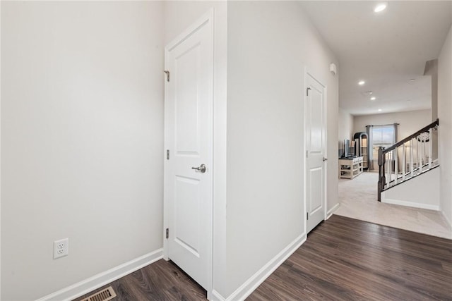 hall with visible vents, baseboards, stairway, wood finished floors, and recessed lighting