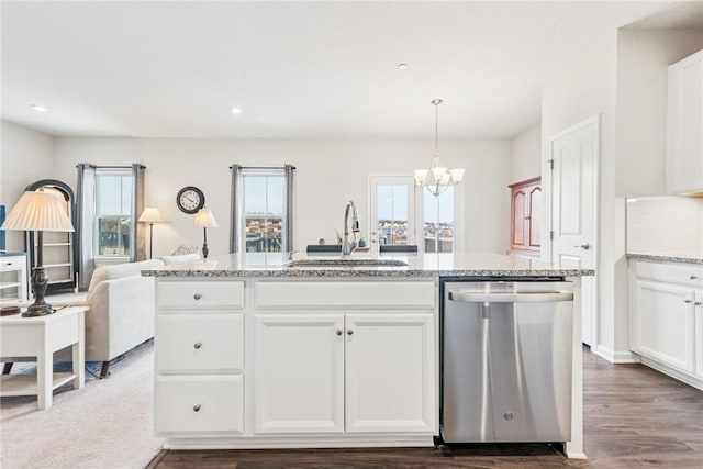 kitchen with hanging light fixtures, open floor plan, white cabinetry, a sink, and dishwasher