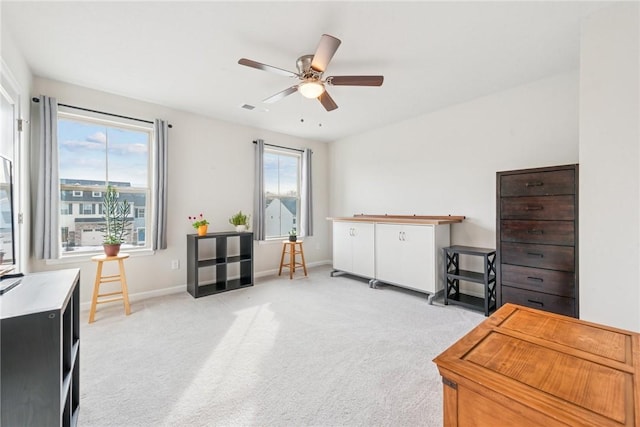 miscellaneous room with light carpet, ceiling fan, plenty of natural light, and baseboards