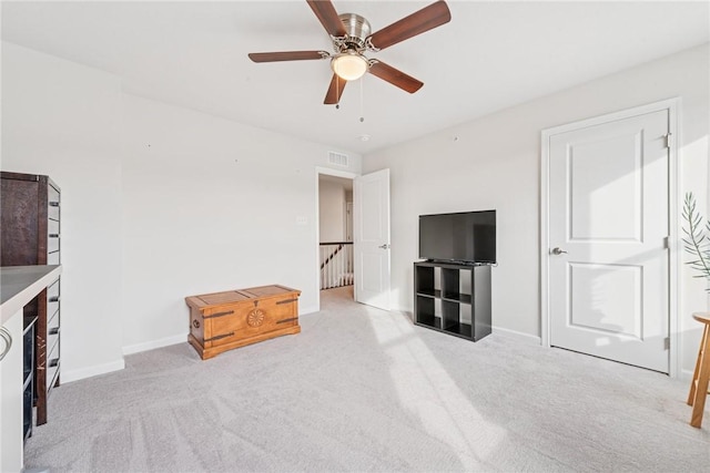 living room with baseboards, a ceiling fan, visible vents, and light colored carpet