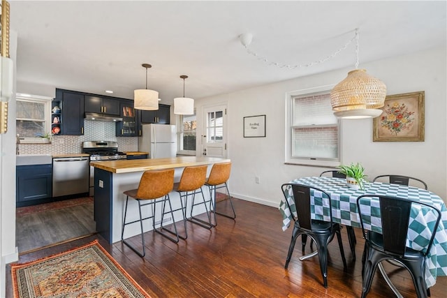 kitchen with stainless steel appliances, butcher block counters, dark wood-style flooring, open shelves, and decorative light fixtures