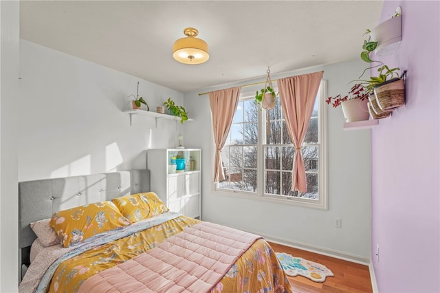 bedroom featuring baseboards and wood finished floors