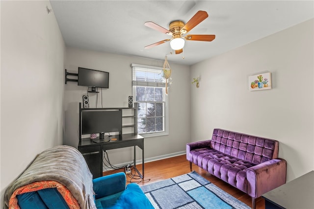 living area featuring ceiling fan, wood finished floors, and baseboards