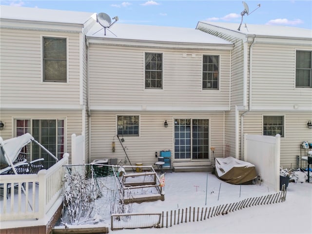 snow covered house with fence