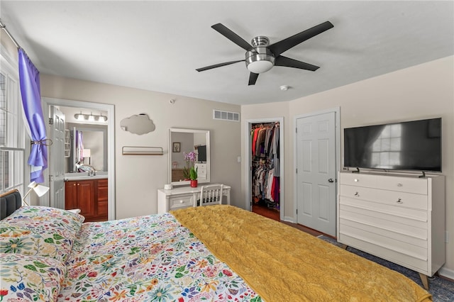 bedroom with visible vents, a ceiling fan, ensuite bathroom, a spacious closet, and a closet