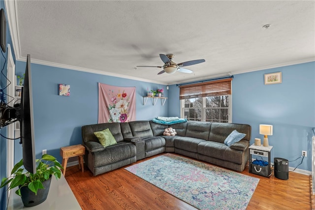 living area with a textured ceiling, ceiling fan, wood finished floors, baseboards, and ornamental molding