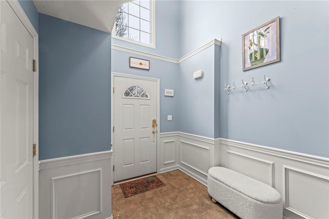 foyer entrance featuring wainscoting and a decorative wall