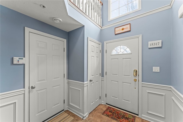 entryway featuring a decorative wall and wainscoting