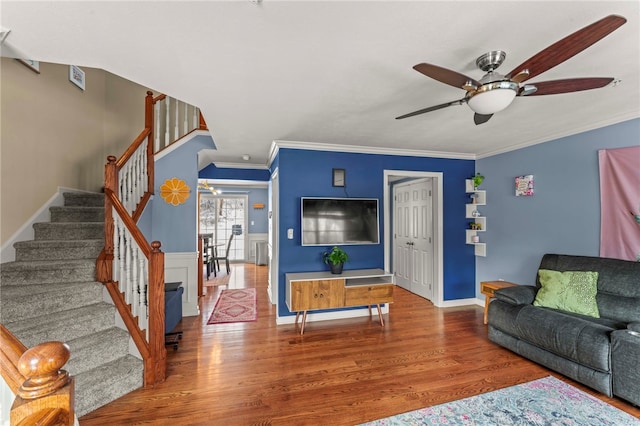 living area with ornamental molding, wood finished floors, and stairs