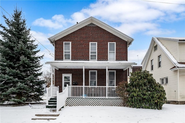 traditional-style house featuring covered porch and brick siding