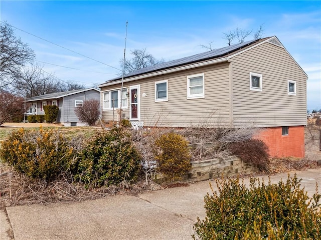 ranch-style home featuring roof mounted solar panels