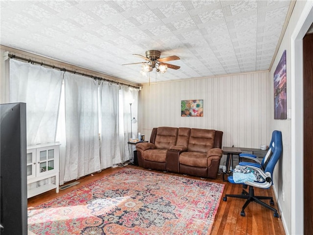 living area featuring a ceiling fan and wood finished floors