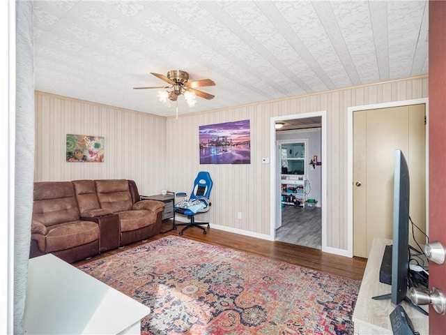 living area featuring ceiling fan, wood finished floors, and baseboards