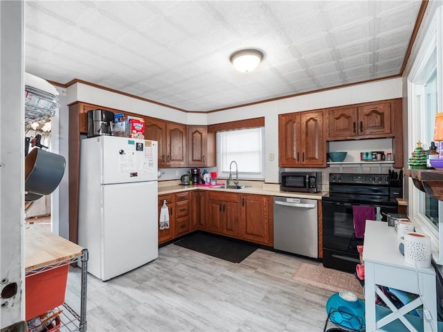 kitchen featuring freestanding refrigerator, light countertops, black range with electric cooktop, and stainless steel dishwasher