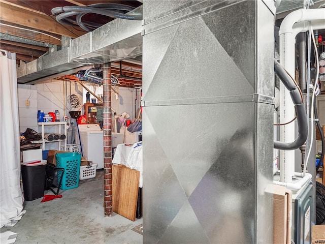 unfinished basement featuring heating unit and washer and clothes dryer