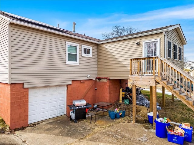 rear view of property with concrete driveway and an attached garage