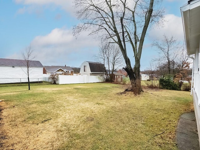 view of yard featuring a residential view, fence, and a shed