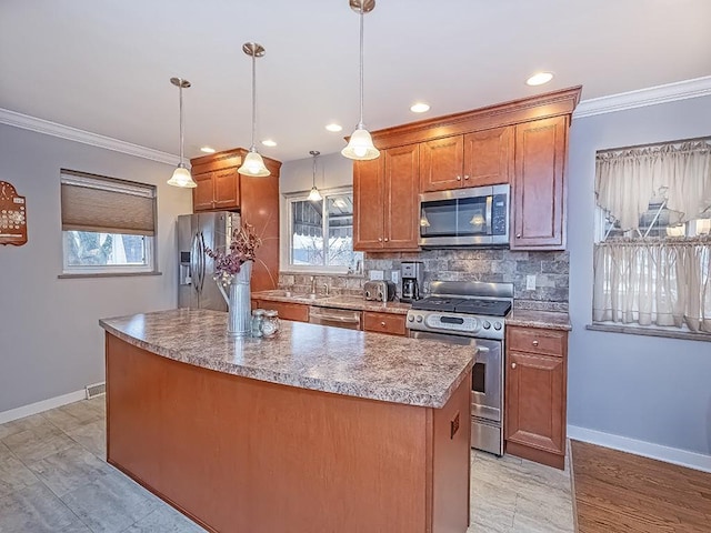 kitchen featuring stainless steel appliances, a center island, ornamental molding, brown cabinets, and pendant lighting