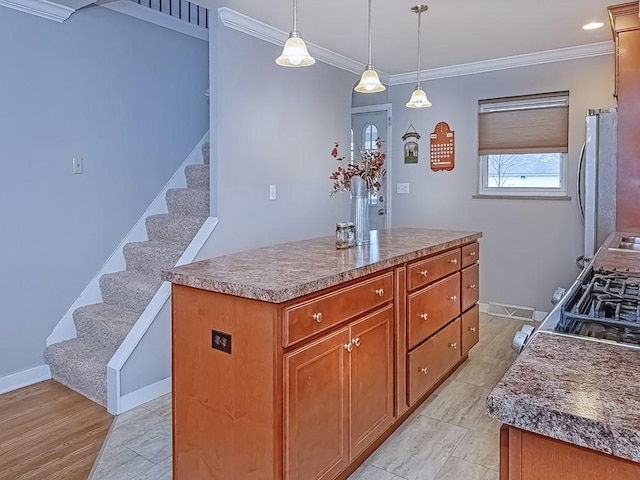 kitchen with brown cabinetry, ornamental molding, freestanding refrigerator, decorative light fixtures, and a center island