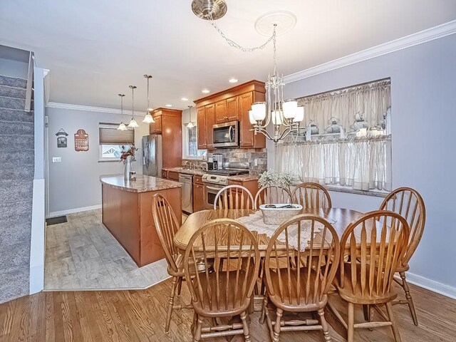 dining area featuring light wood-style flooring, a notable chandelier, baseboards, stairs, and crown molding