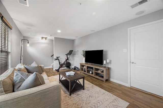 living room featuring recessed lighting, wood finished floors, visible vents, and baseboards