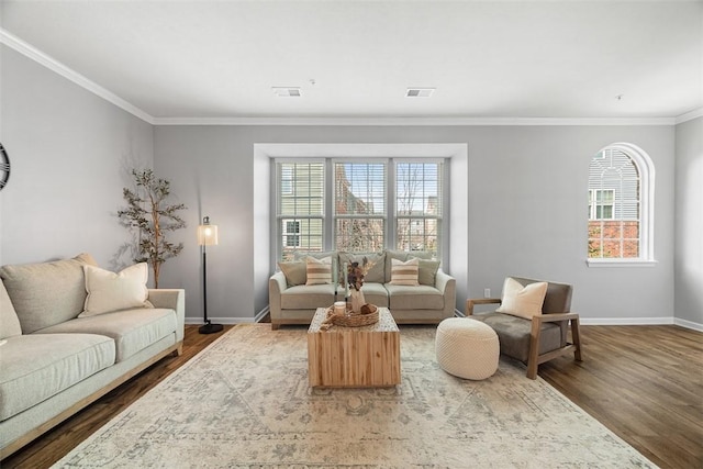 living area featuring a wealth of natural light, visible vents, baseboards, and wood finished floors