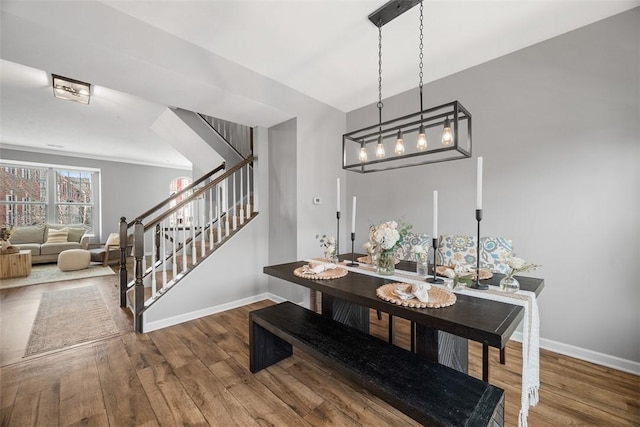 dining space with stairs, wood finished floors, and baseboards