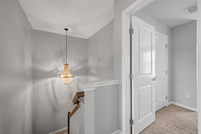 hall with baseboards, carpet flooring, and an upstairs landing