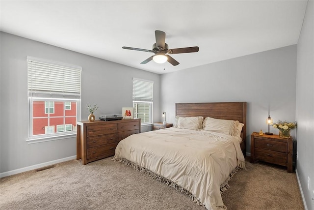 carpeted bedroom featuring multiple windows, visible vents, and baseboards