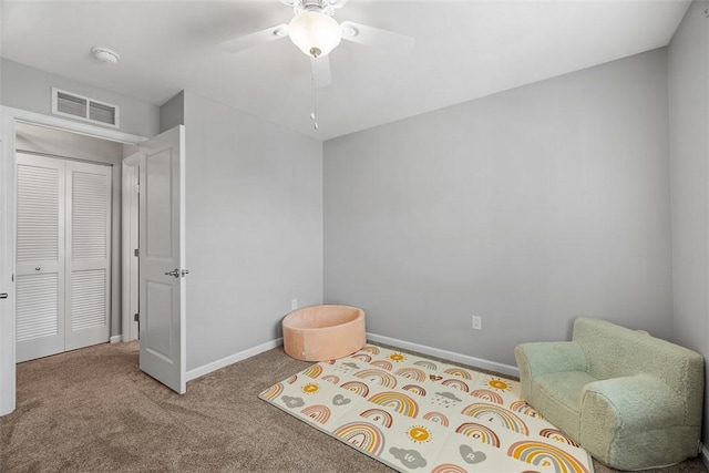 sitting room with carpet floors, baseboards, visible vents, and ceiling fan