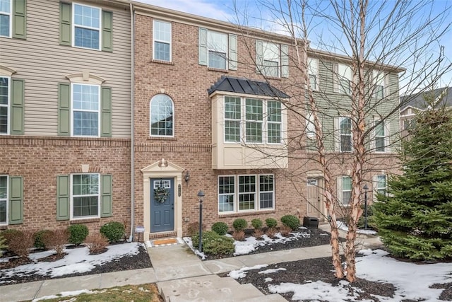 townhome / multi-family property featuring brick siding and a standing seam roof