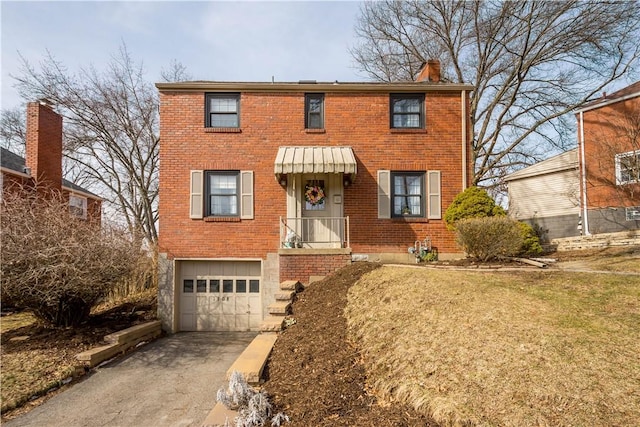 view of front of home featuring aphalt driveway, brick siding, a chimney, an attached garage, and a front yard