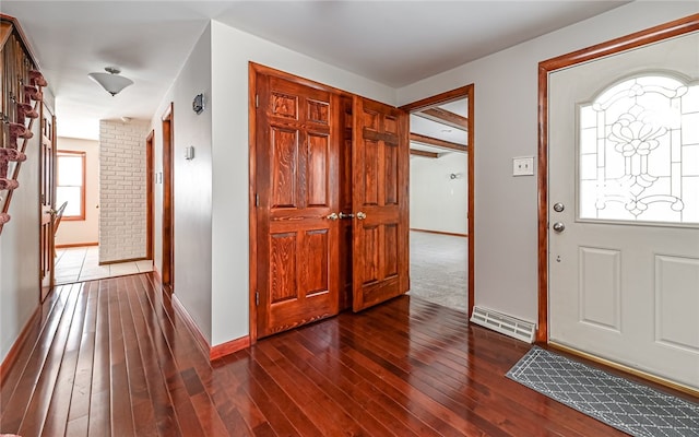 foyer entrance featuring visible vents, dark wood finished floors, and baseboards