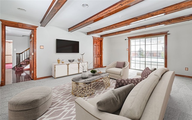 living room featuring beam ceiling, light carpet, baseboards, and stairs