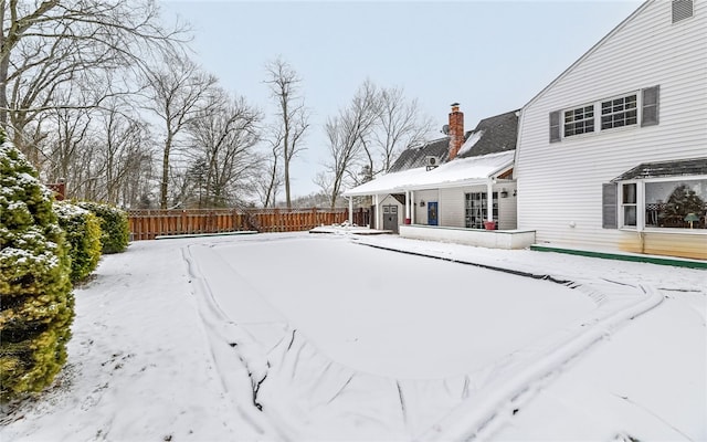 yard covered in snow featuring fence