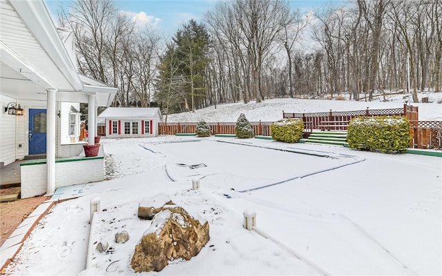 snowy yard featuring fence and an outdoor structure