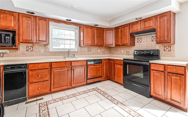 kitchen with a sink, paneled dishwasher, light countertops, and black electric range oven