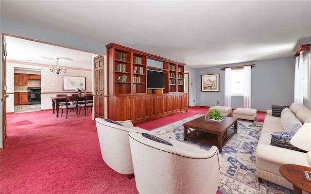 carpeted living room featuring baseboards, an inviting chandelier, and wallpapered walls