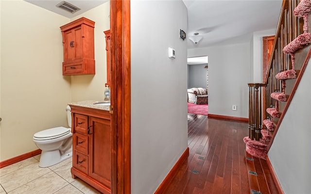 bathroom with toilet, baseboards, visible vents, and vanity