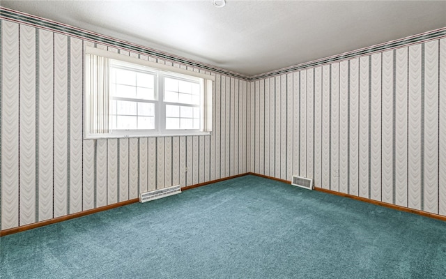 carpeted spare room with baseboards, visible vents, and wallpapered walls