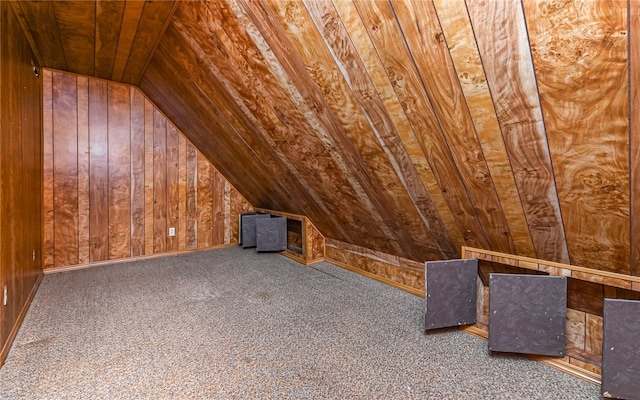 bonus room featuring lofted ceiling, dark colored carpet, wood walls, and wooden ceiling